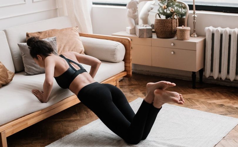 A woman stretches on a mat in a stylish living room, promoting a healthy lifestyle.